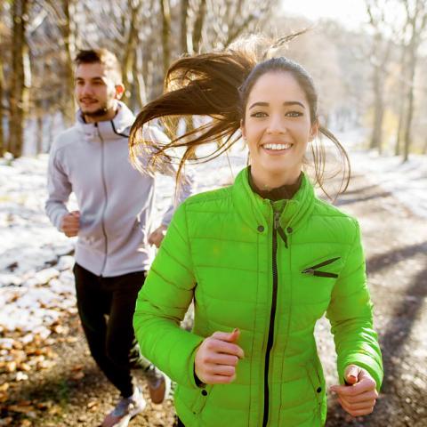 Couple running in winter landscape