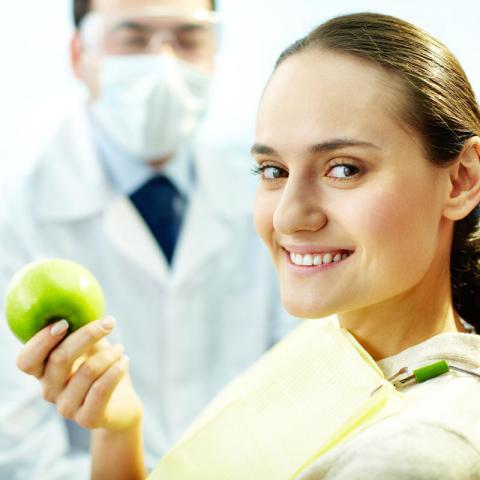 woman at dentist with apple