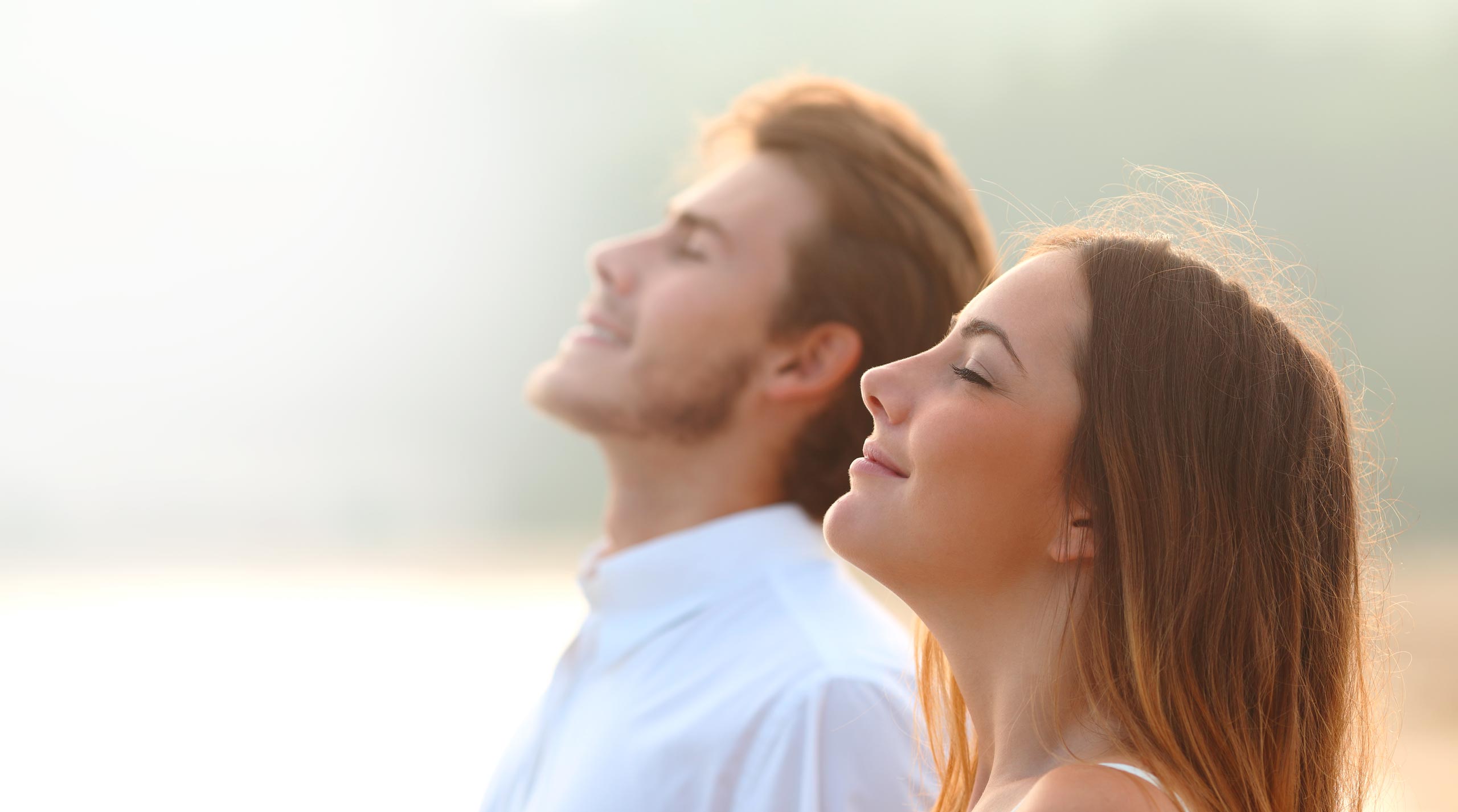 faces of a couple enjoying the sun and fresh air with closed eyes